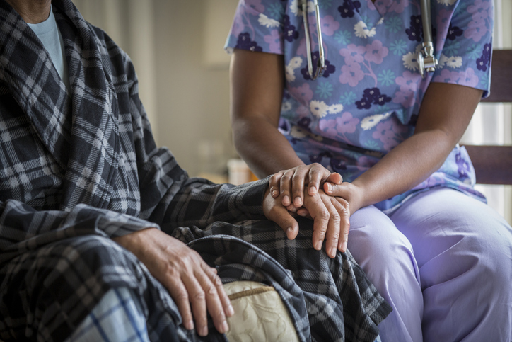 Caregiver comforting hospice patient.